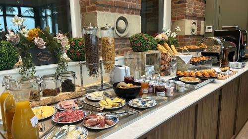 un buffet avec de nombreux types de nourriture différents sur un comptoir dans l'établissement Logis Hôtel- Restaurant Le Relais Guillaume de Normandy, à Saint-Valery-sur-Somme