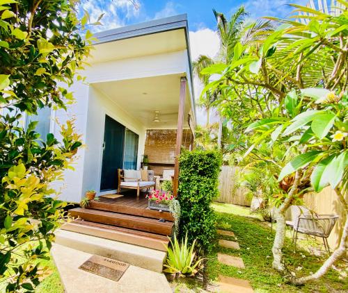 a home with a garden with a patio and trees at Caba Beach Condo Highly rated, roomy 2-bedroom cabin, walk to the beach! Private & Quiet in Cabarita Beach