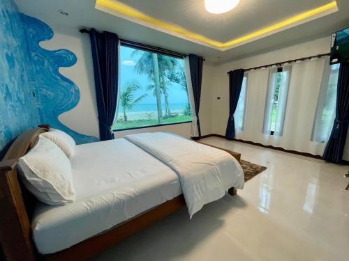 a bedroom with a large bed with a large window at Baan rabianglay 2 in Ban Hin Sam Kon