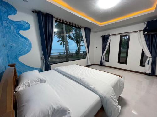 a bedroom with two beds and a large window at Baan rabianglay 2 in Ban Hin Sam Kon