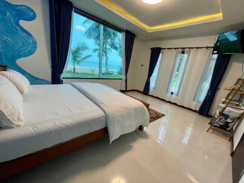a bedroom with a large bed and a large window at Baan rabianglay 2 in Ban Hin Sam Kon