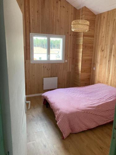- une chambre avec un lit rose dans une pièce dotée d'une fenêtre dans l'établissement Great big holiday house, à Vielle-Saint-Girons