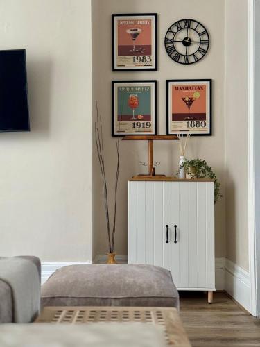 a living room with a couch and a clock on the wall at Spacious 4-Bed Apartment In City Centre in Brighton & Hove