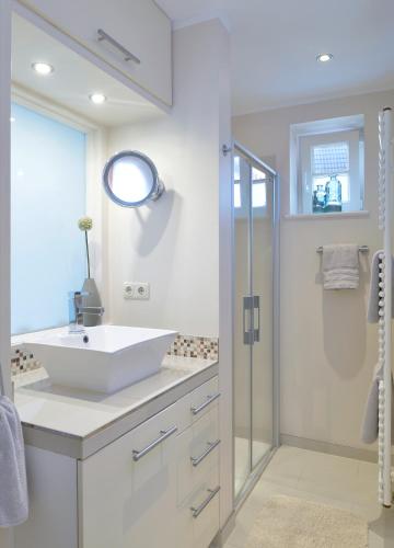 a white bathroom with a sink and a shower at Bines Hues in List