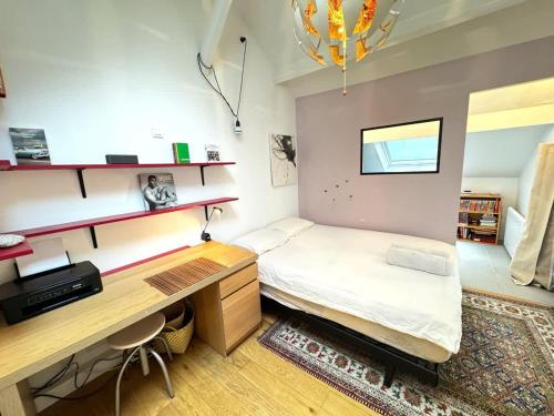 une petite chambre avec un lit et un bureau dans l'établissement The Pianist - House Loft - Heart of Montparnasse, à Paris