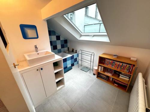 La salle de bains est pourvue d'un lavabo et d'une lucarne. dans l'établissement The Pianist - House Loft - Heart of Montparnasse, à Paris