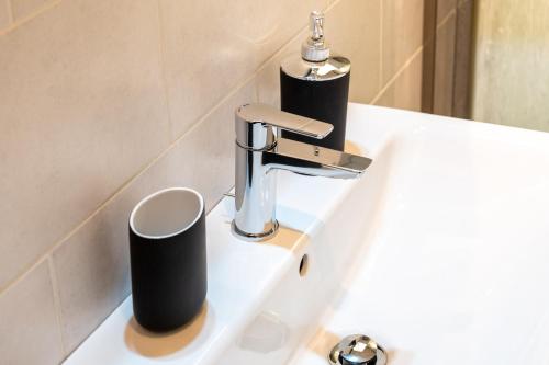 a sink with a faucet and two cups on it at Bilocale Incantevole in Casalecchio di Reno