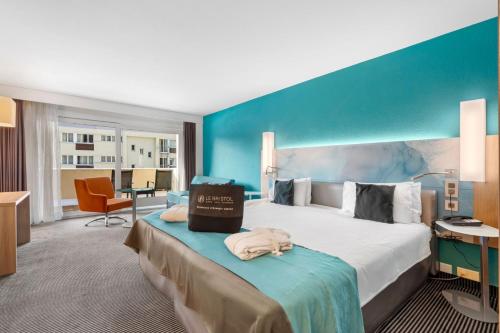 a hotel room with a large bed with a blue wall at Le Bristol Leukerbad in Leukerbad