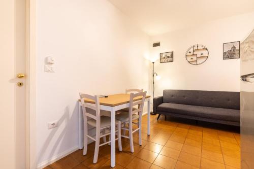 a dining room with a table and a couch at Bilocale Incantevole in Casalecchio di Reno