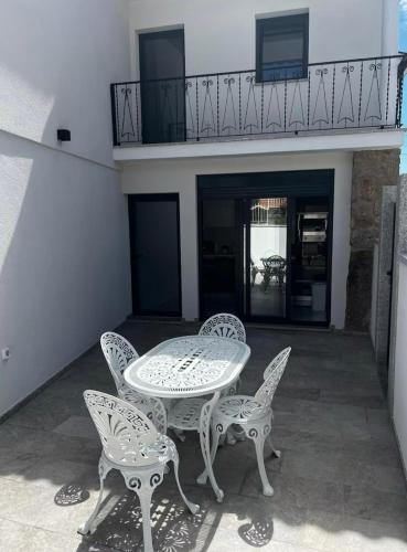 a patio with a table and chairs and a balcony at Maison de village in Dornelas