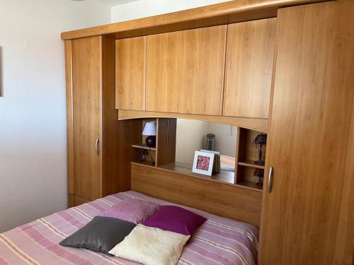 une chambre avec un lit avec une armoire en bois dans l'établissement Apartment Le Goëland, à Arcachon