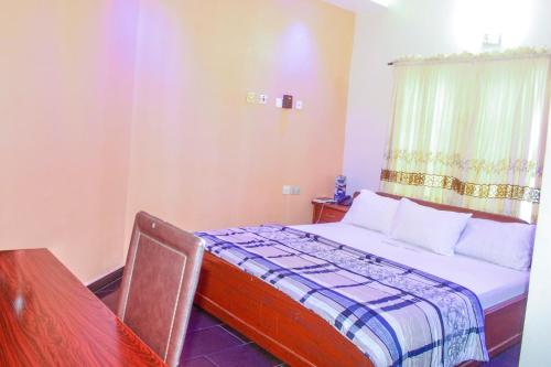 a small bedroom with a bed and a window at Emrosy in Uyo