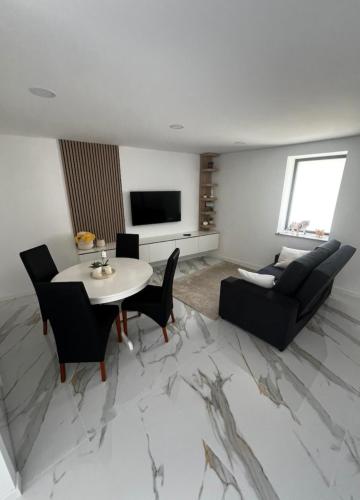 a living room with a table and a couch at Maison de village in Dornelas