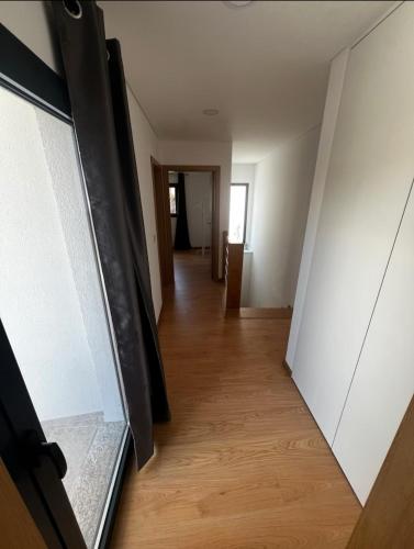an empty hallway with a door and a wooden floor at Maison de village in Dornelas