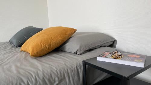 - un lit avec un oreiller et une table avec un livre dans l'établissement Studio aux portes de Paris, à Ivry-sur-Seine