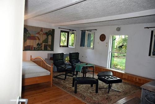a room with a bed and chairs and a table at Domek Myśliwski in Zatom Nowy