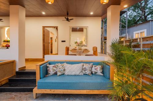a blue couch on the front porch of a house at ELIVAAS House of Neptune 1 BHK Boutique Villa on the Beach in Morjim