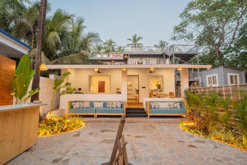 a house with two couches on a patio at ELIVAAS House of Neptune 1 BHK Boutique Villa on the Beach in Morjim