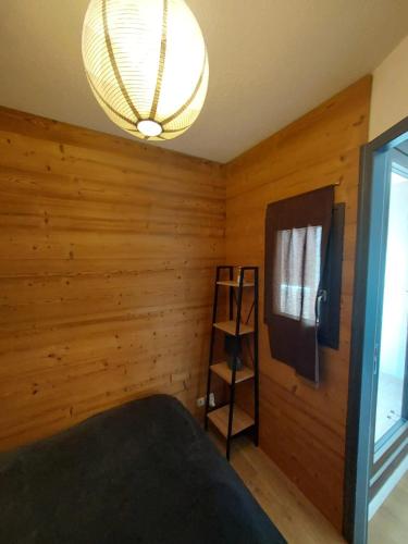 Cette chambre est dotée d'un mur en bois avec un lit et une échelle. dans l'établissement Appartement cosy à L'Alpe d'Huez 27 m² avec vue montagne, à L'Alpe-d'Huez
