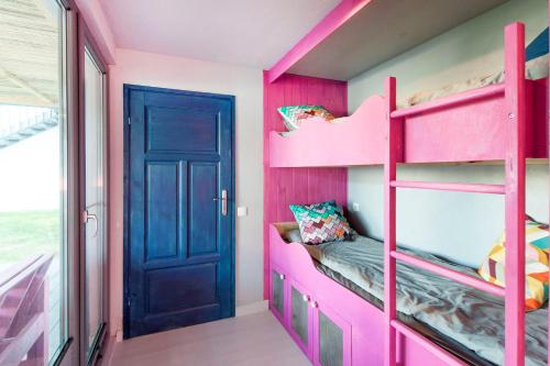 a pink bunk bed in a room with a door at SOBIESZEPTY Odetchnij ciszą in Gdańsk