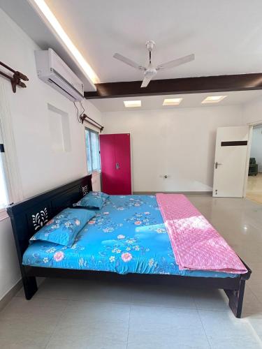 a bedroom with a bed with a blue comforter at Luxury Villa in Heart of the city in Haidar Sāhibgūda
