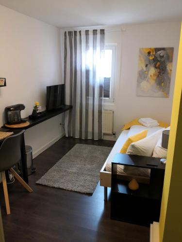 a bedroom with a bed and a desk and a television at Stilvolle Altbauwohnung Apartment Zimt & Zucker in Höhr-Grenzhausen