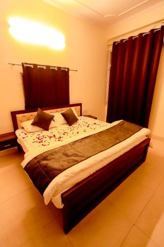 a bedroom with a large bed with red curtains at Moon Land Hotel in Jaipur