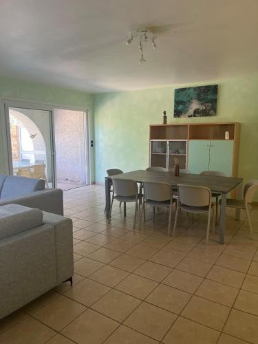 un salon avec une table, des chaises et un canapé dans l'établissement Les Villas Maristella, Villa Crenu, à Aregno