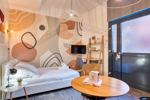 une petite pièce avec un lit et une table dans l'établissement Déborah studio calme lit et place de parking, à Rouen