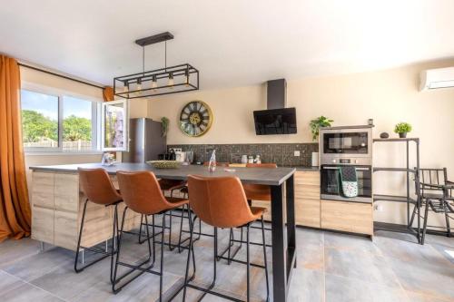 une cuisine avec une grande table et des chaises en bois dans l'établissement Les Lauriers de Catherine, à Saint-Jean-de-Monts