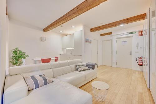a living room with a white couch and a table at La Chapitela 7 by Clabao in Pamplona