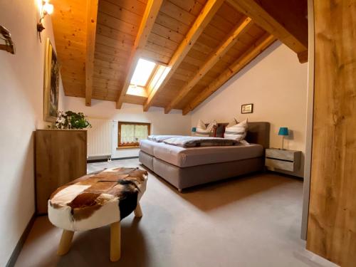 een slaapkamer met een groot bed en een houten plafond bij Haus am Wiesbach in Reit im Winkl