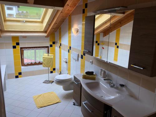 een badkamer met een wastafel en een toilet bij Haus am Wiesbach in Reit im Winkl