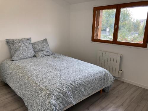 une chambre avec un lit avec une couette et une fenêtre dans l'établissement 2 pièces Gagny moins de 2 min du RER, à Gagny