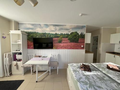 a bedroom with a table and a painting on the wall at Heidelandhaus Zühlke mit gemütlicher Südterrasse in Soltau
