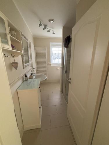 a white bathroom with a sink and a shower at Heidelandhaus Zühlke mit gemütlicher Südterrasse in Soltau