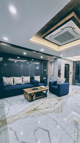 a living room with a blue couch and a table at Hotel Akshaya in Port Blair