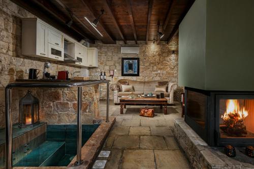 a living room with a fireplace and a couch at Oinoessa Traditional Boutique Guest Houses in Lofou