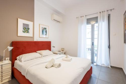 a bedroom with a large bed with two towels on it at Renovated 5 Bdr House near Acropolis - New Beds, Terrace & Green Yard in Athens
