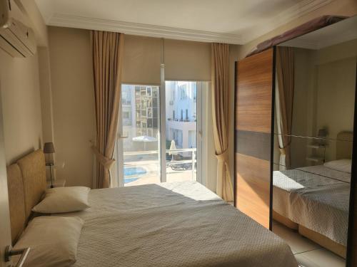 a bedroom with a bed and a view of a balcony at Antalya belek 4 nirvana club first floor two bedrooms pool view with water slide close to center - belek beach park in Belek