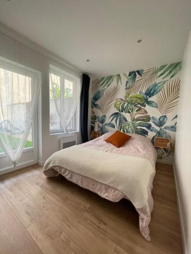 une chambre avec un lit et une fresque de plantes dans l'établissement - Chez nous -, à Clermont-Ferrand