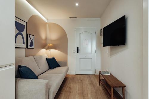 a living room with a couch and a flat screen tv at Vibe Apartments by Olala Homes in Hospitalet de Llobregat