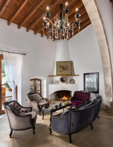 a living room with a chandelier and a fireplace at Oinoessa Traditional Boutique Guest Houses in Lofou