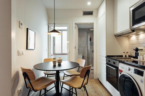 a dining room with a table and chairs in a kitchen at Vibe Apartments by Olala Homes in Hospitalet de Llobregat