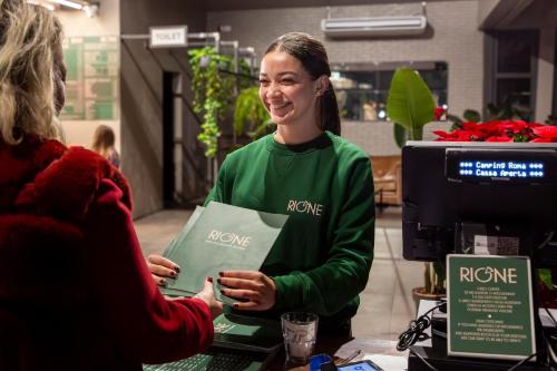 a woman standing at a counter talking to a customer at hu Roma Camping In Town in Rome