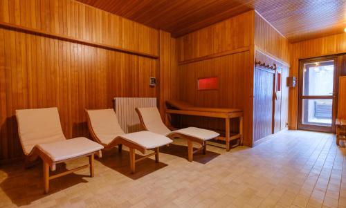 a room with a table and chairs and a piano at Forte Family Village - Azzurro Club in Sella Nevea