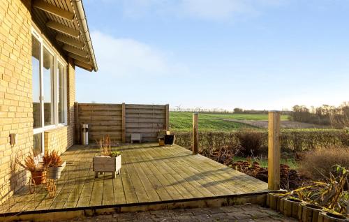 a wooden deck with a chair on a house at 2 Bedroom Nice Home In Roslev in Roslev