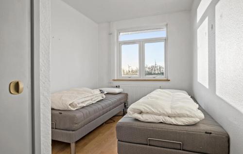 two beds in a small room with a window at 2 Bedroom Nice Home In Roslev in Roslev