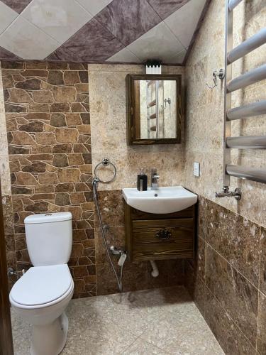 un baño con inodoro y lavabo en Qahramanoffshale, en Gabala