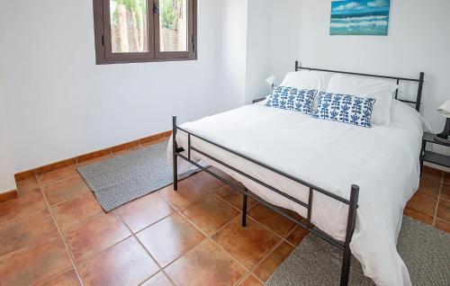 a bed with blue and white pillows in a room at Nice Home In Guillena With Wifi in Guillena